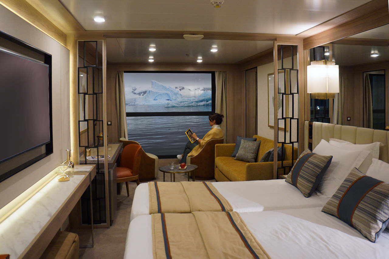 A passenger kicking back in The World Explorer's Infinity Suite.