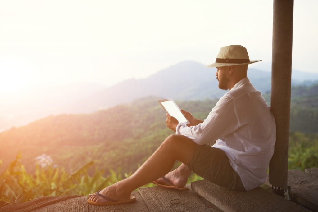 A gay man sits alone during a yoga retreat to read.