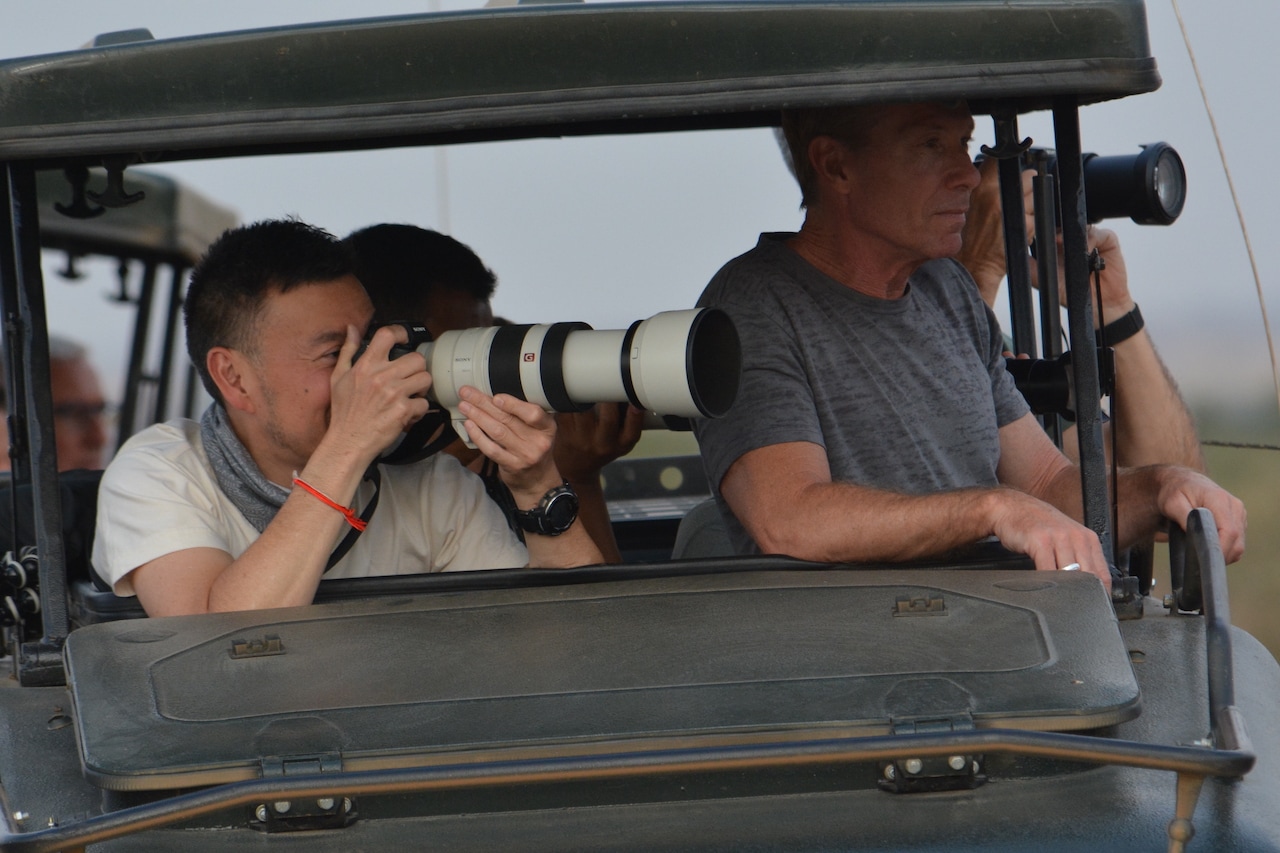 Travellers photograph wildlife in Africa.