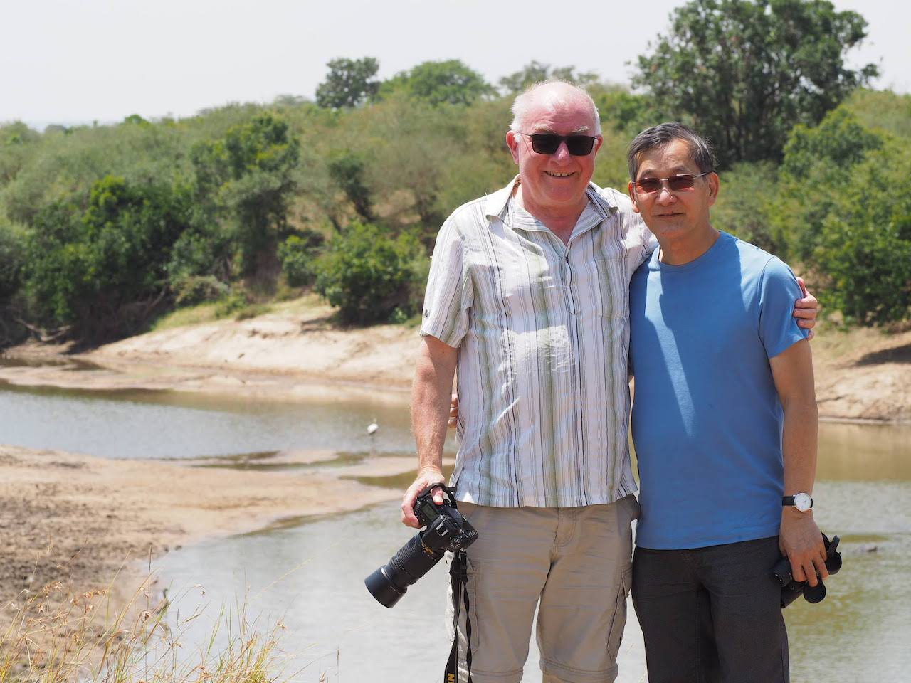 A gay couple pose for a photo between safari drives in Kenya.